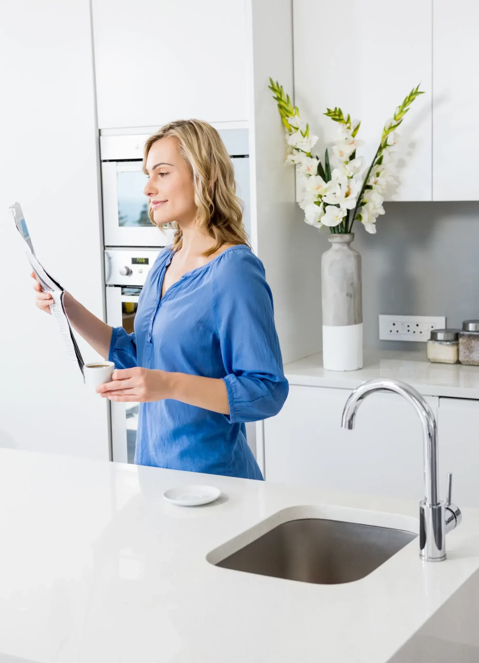 Woman reading news paper in beautifully designed kitchen