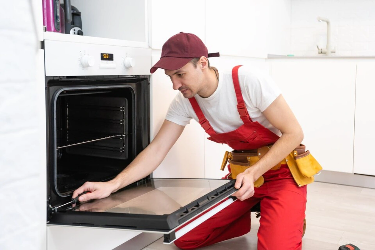 Appliance repairman fixing an oven in Nepean