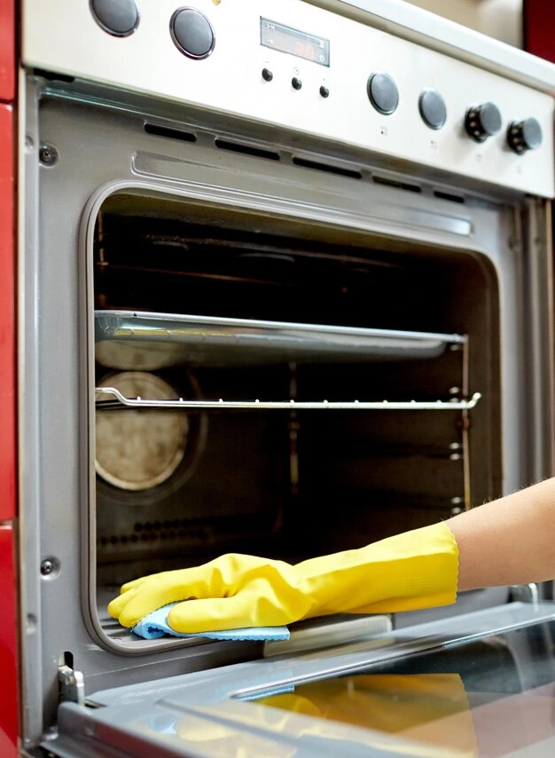 a woman cleaning oven with baking soda